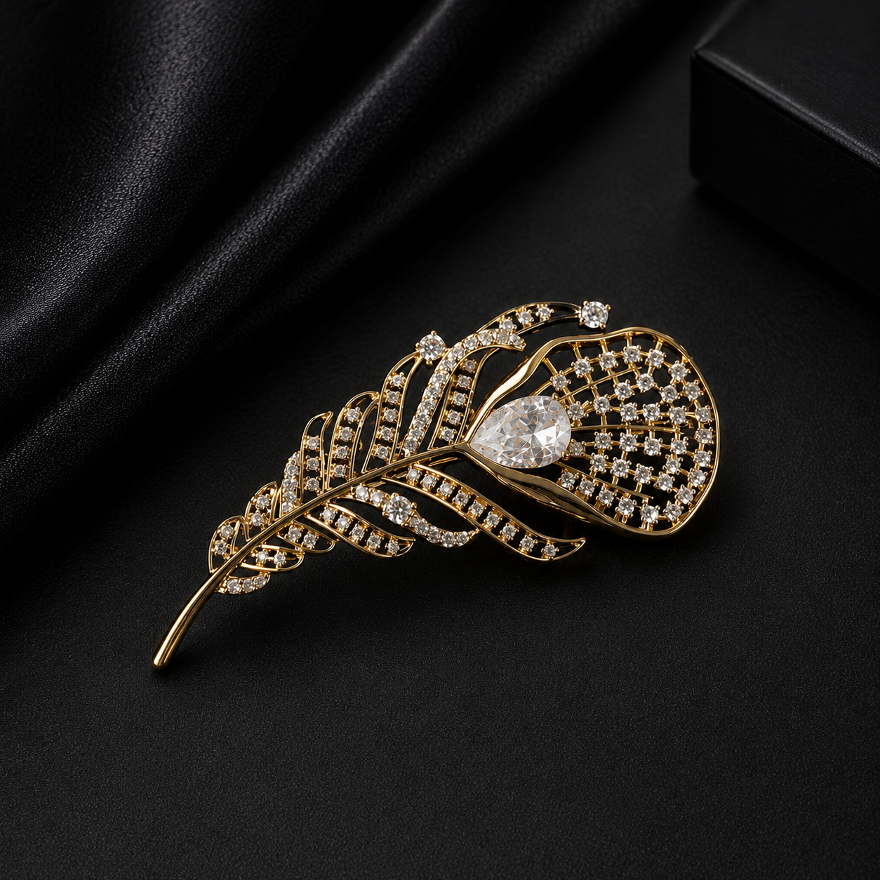 Gold feather-shaped brooch with diamond details on a black background