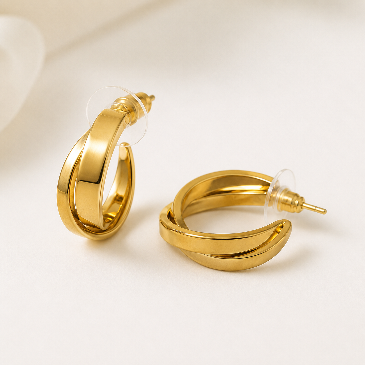 Gold hoop earrings on a light beige background