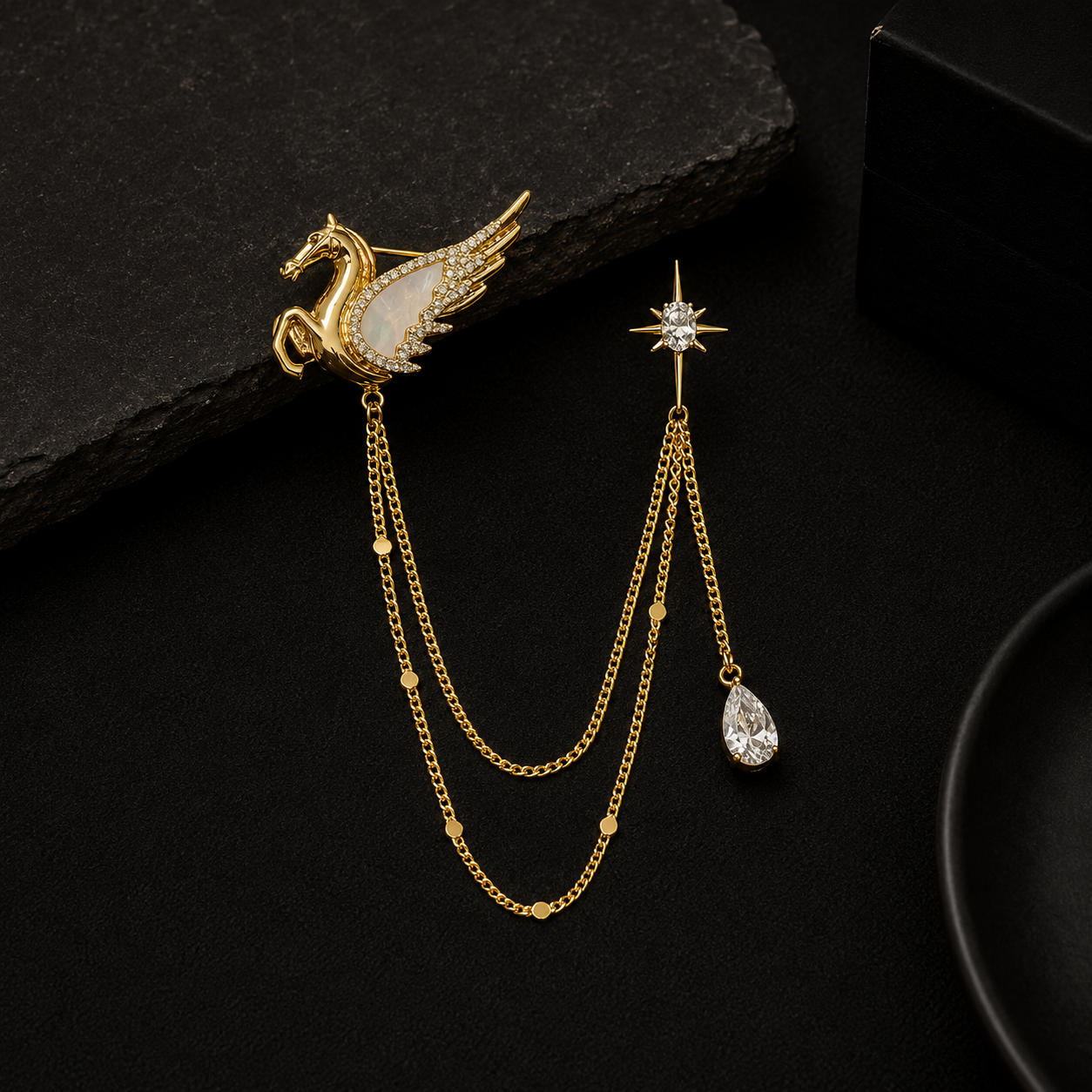 Gold brooch and earring set on a black background