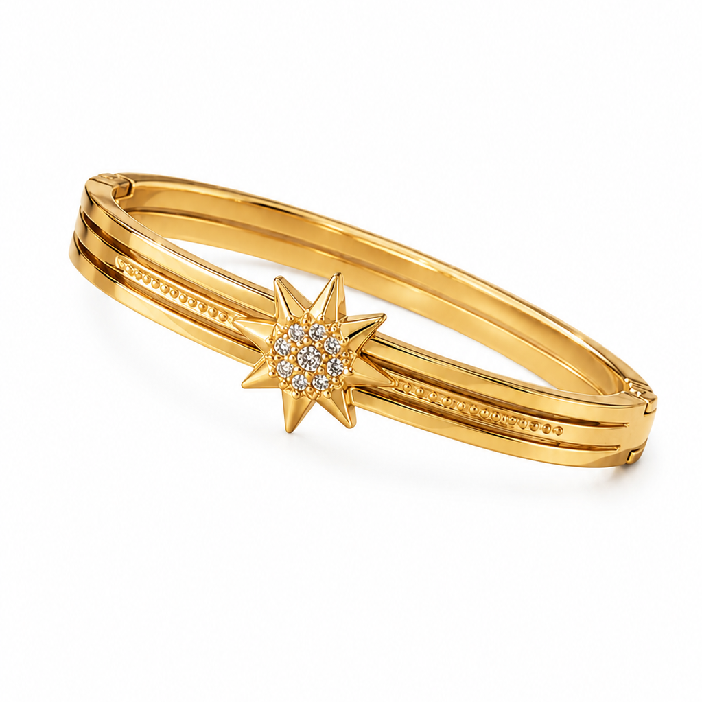 A gold-plated triple-band hinged bangle bracelet featuring a central starburst charm set with small clear stones, shown on a plain white background.