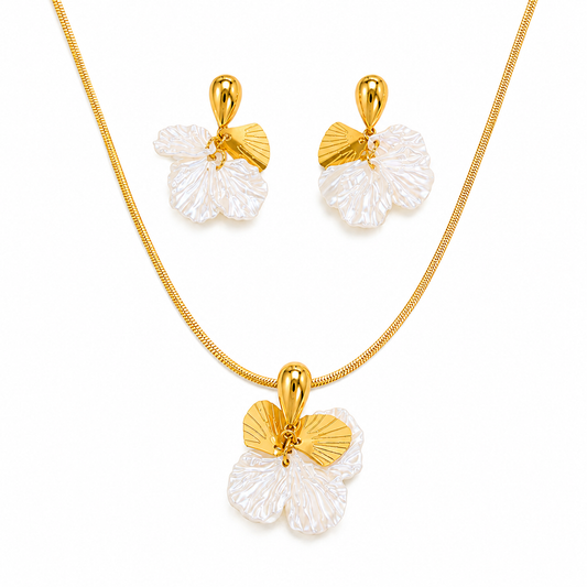 Gold necklace and matching earrings with flower-shaped pendants featuring textured white petals and polished gold centers, displayed on a clean white background.