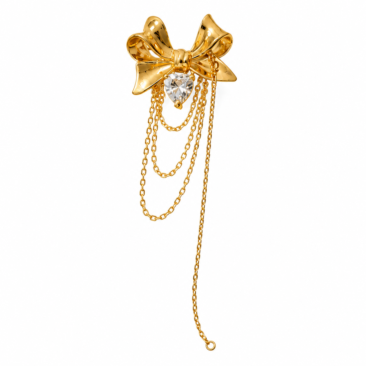 A gold bow-shaped earring with a clear heart-shaped crystal and three dangling chain tails, shown on a plain white background.