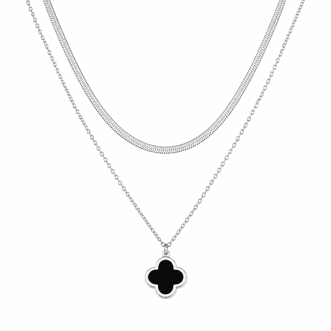 A silver-toned double-strand necklace featuring a textured chain and a delicate cable chain with a black clover pendant, shown on a plain white background.