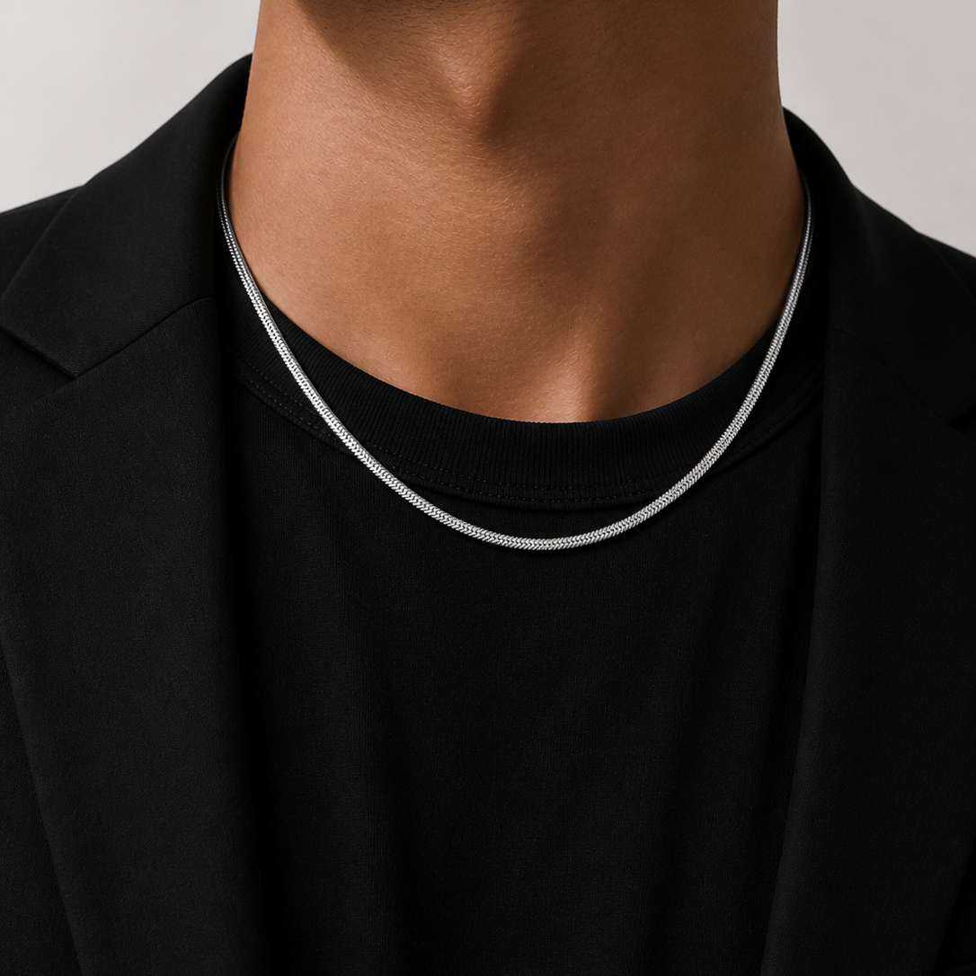 Close-up of a person wearing a black shirt with a white trim around the collar against a neutral background