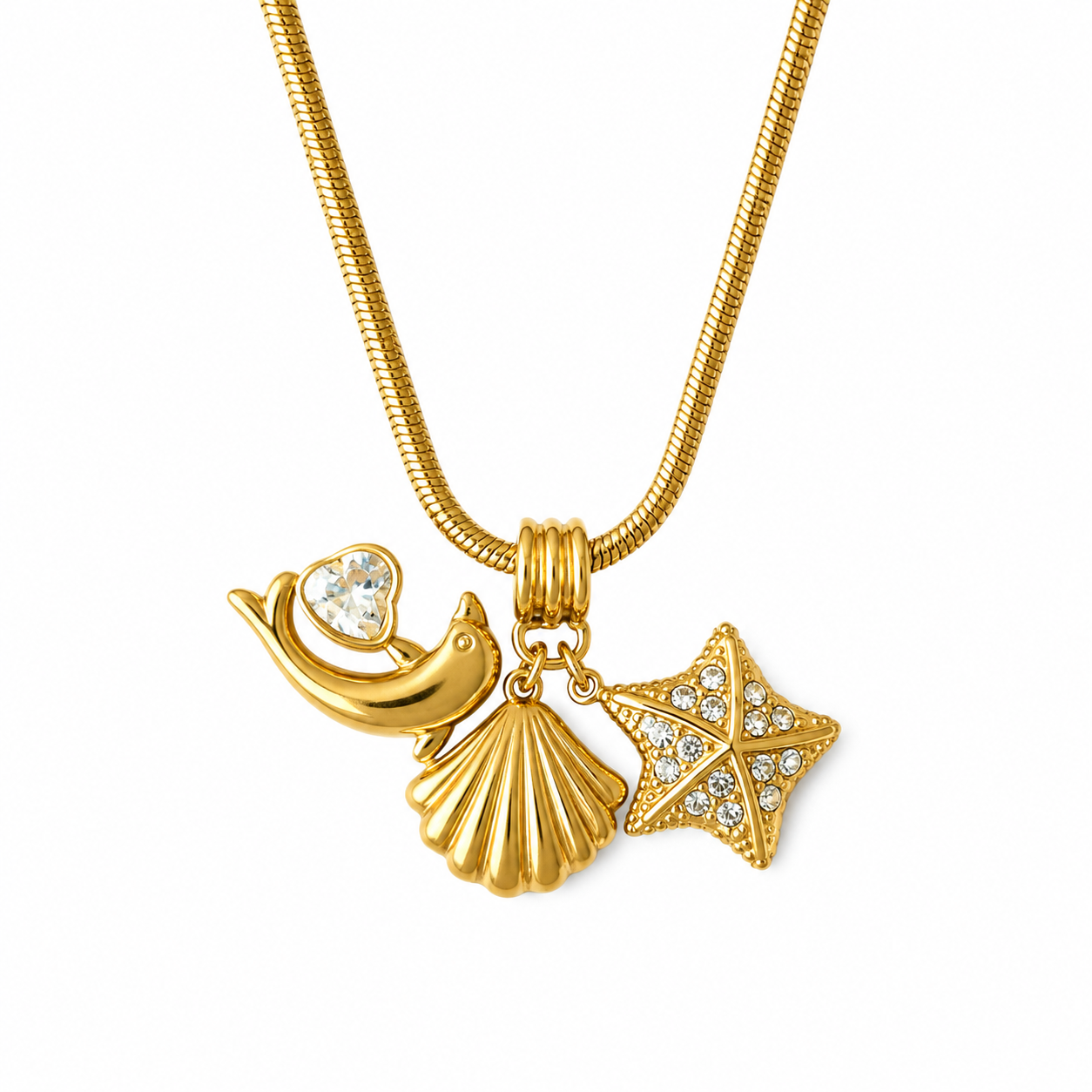 Gold-tone snake chain necklace with a seashell and starfish pendant set with clear rhinestones, alongside a gold bird charm holding a heart-shaped crystal, on a white background.