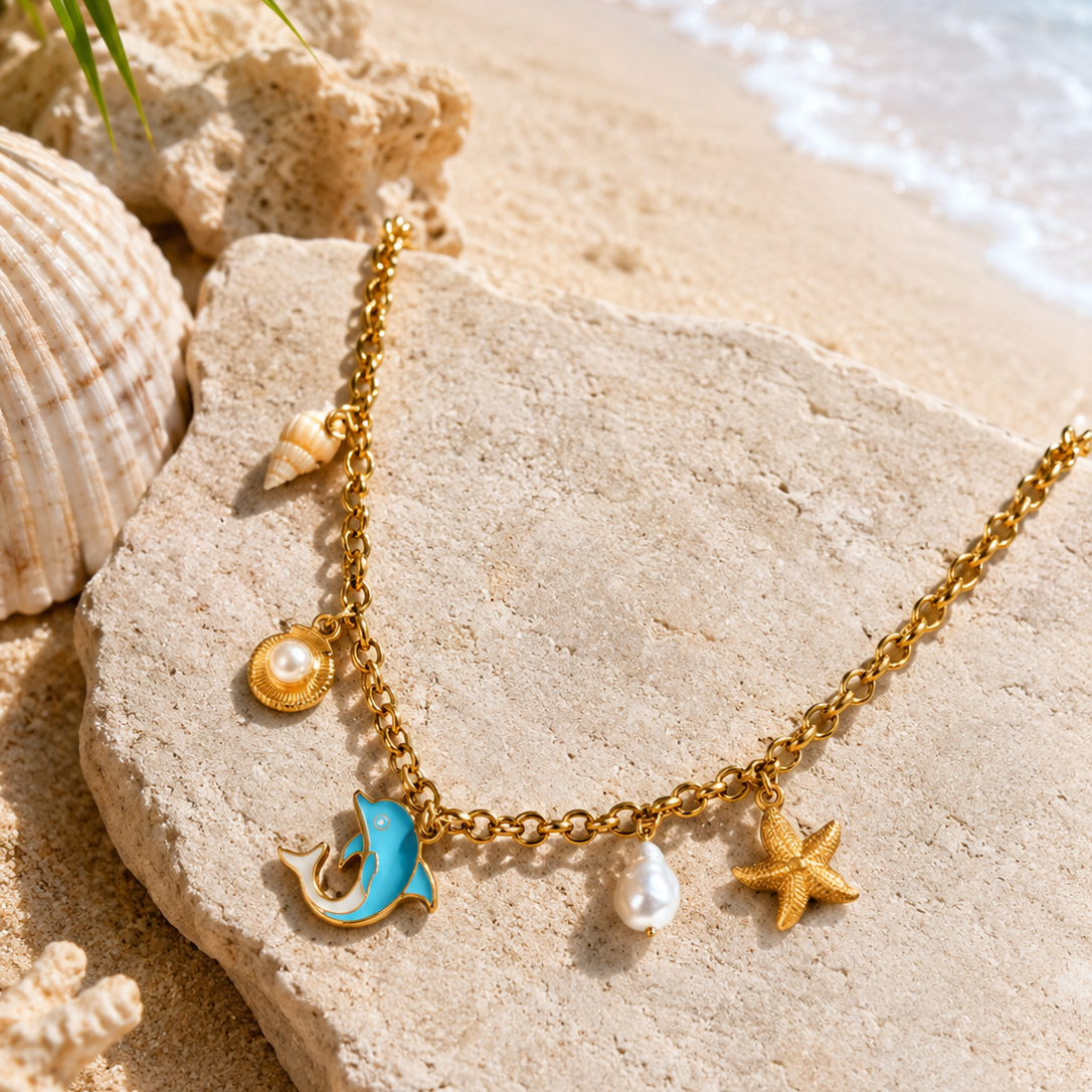 Gold necklace with sea-themed charms on a beach setting