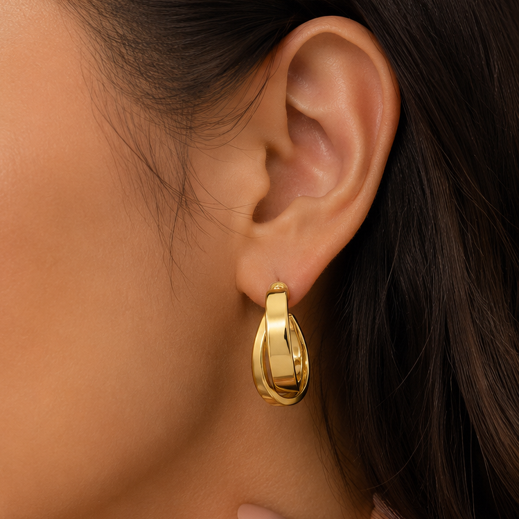 Gold hoop earring worn by a person with dark hair.