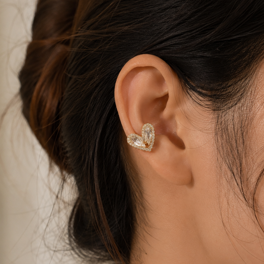 Close-up of an ear wearing a heart-shaped earring with a blurred background