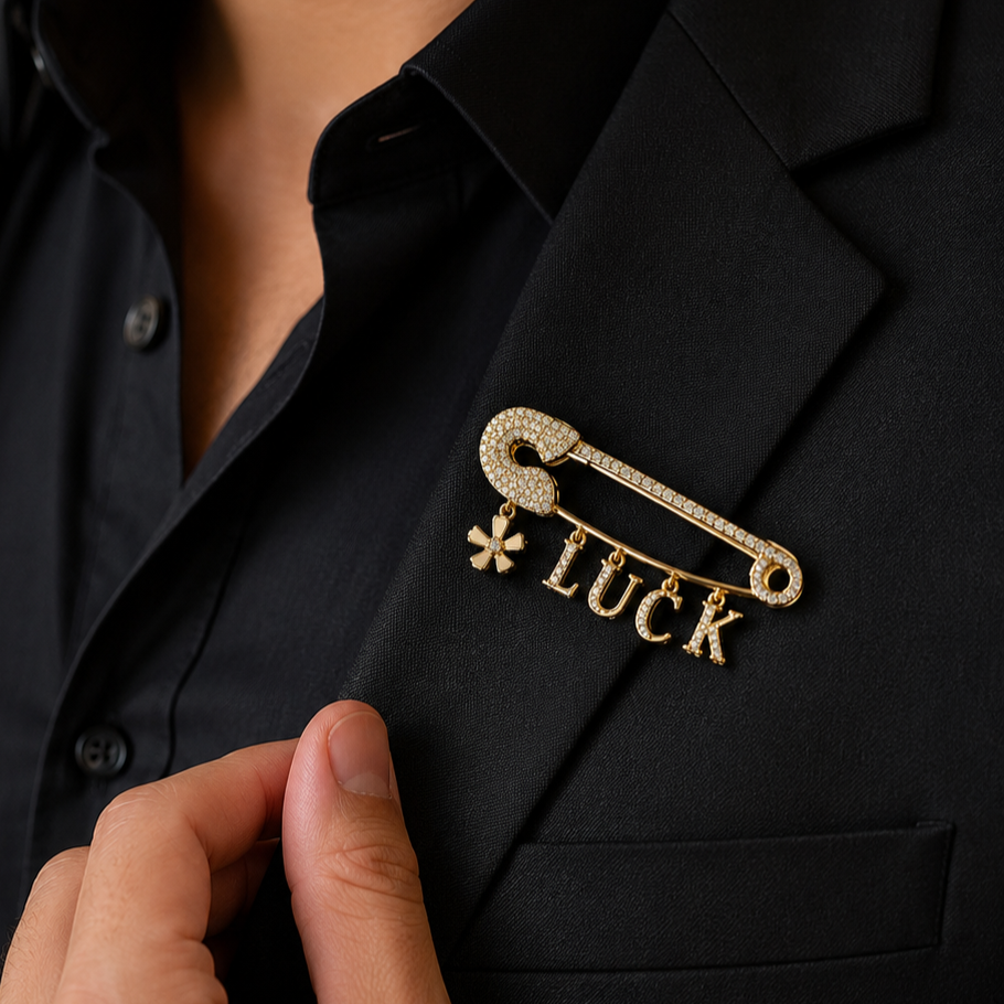 Gold 'LUCK' brooch on a black suit jacket