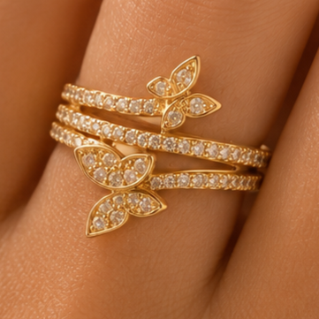 Gold butterfly bracelet with clear stones on a wrist against a skin background